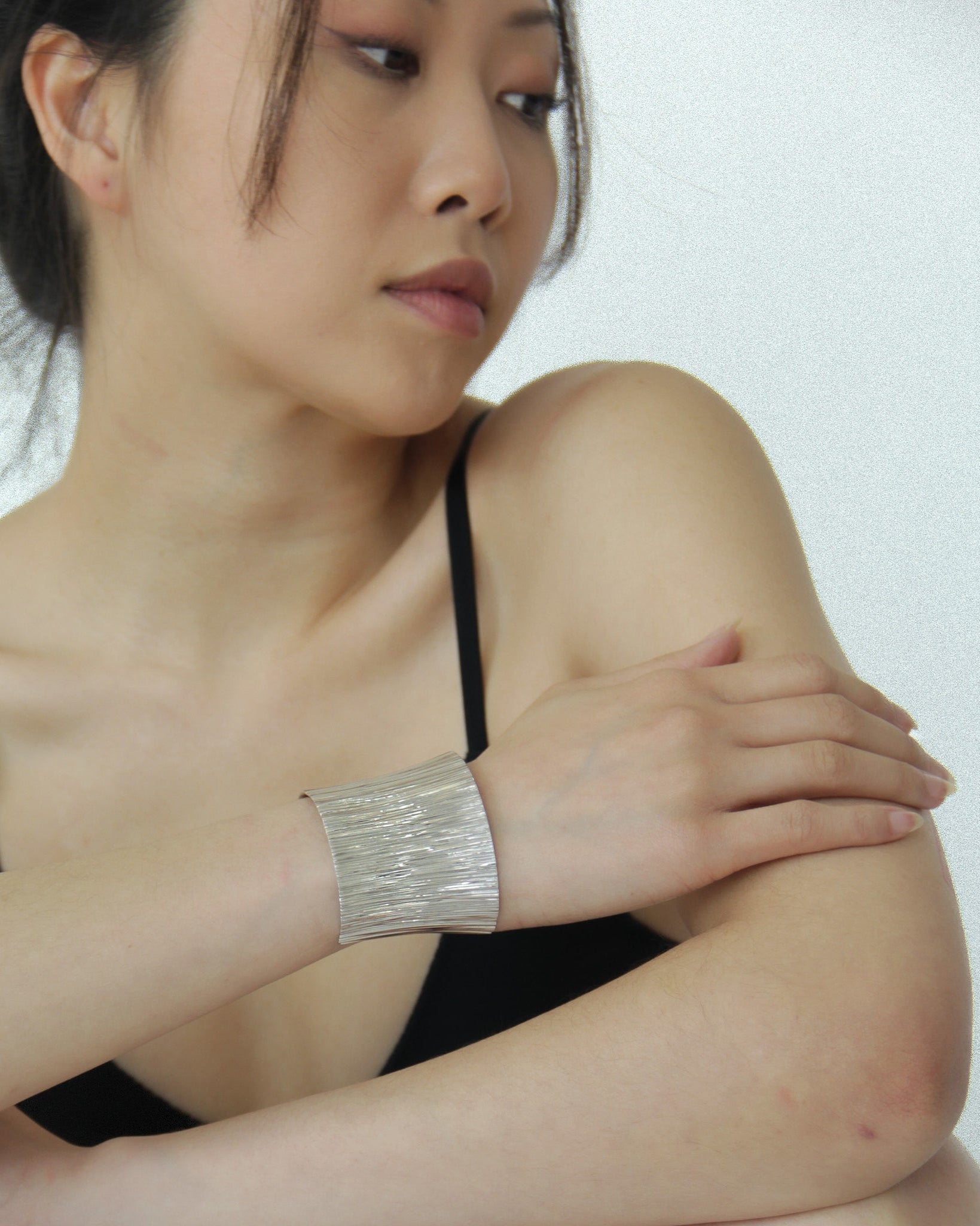 model wearing Cascade Plunge Cuff Bracelet inspired by waterfalls with intricate texture in silver finish