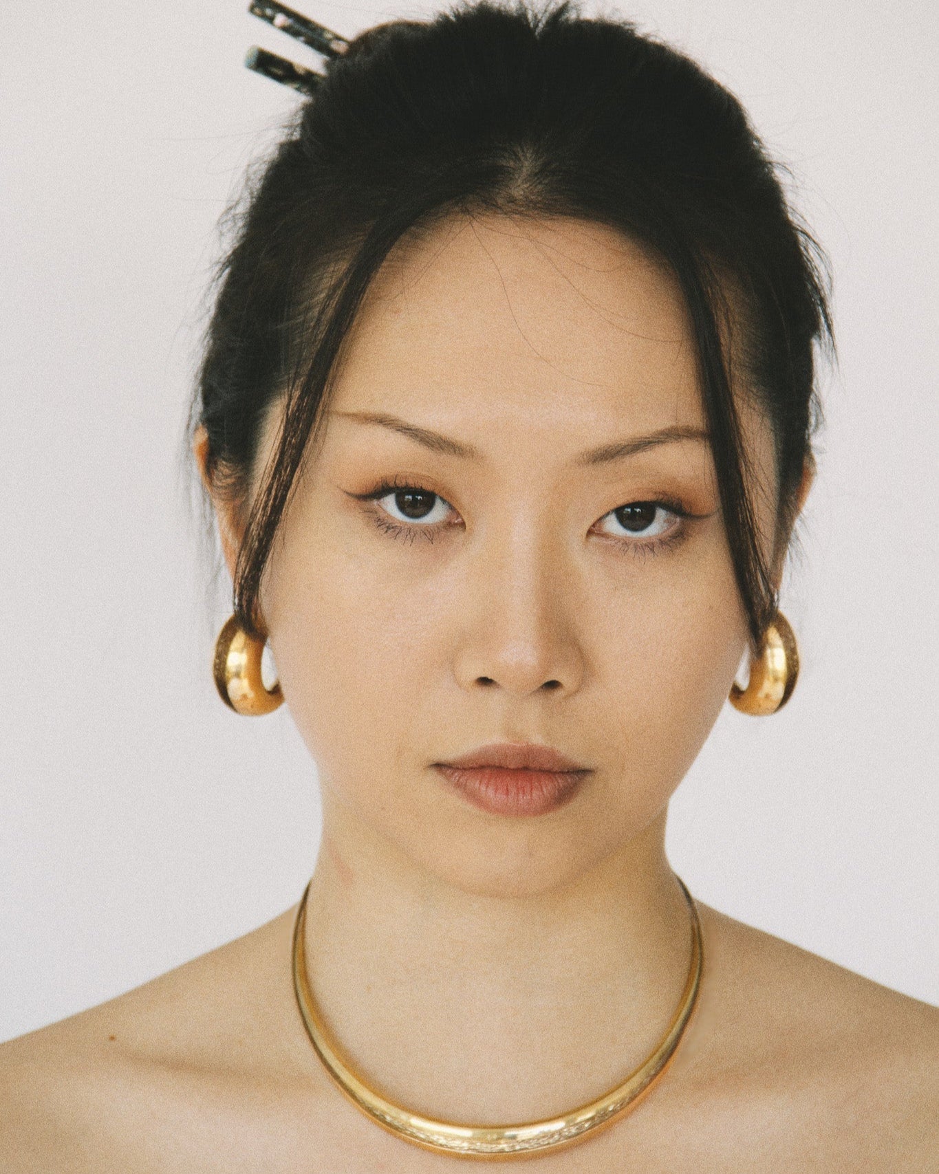 model wearing Currents Chunky Hoop Earrings and chocker necklace made with Brass in 24k gold finish with smooth exterior and textured interior