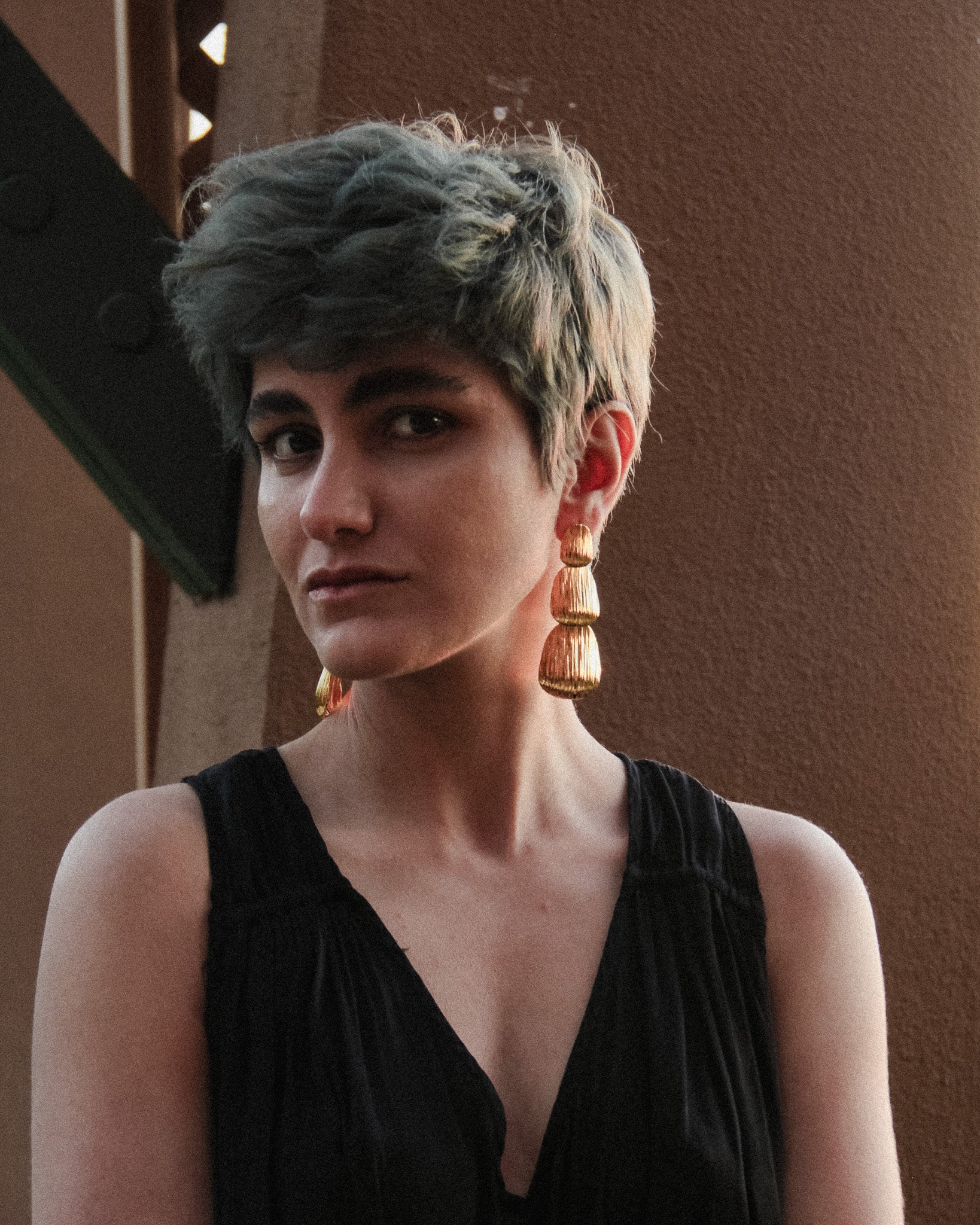 Angle view of the gold Cascade layered earrings showing the stacked form