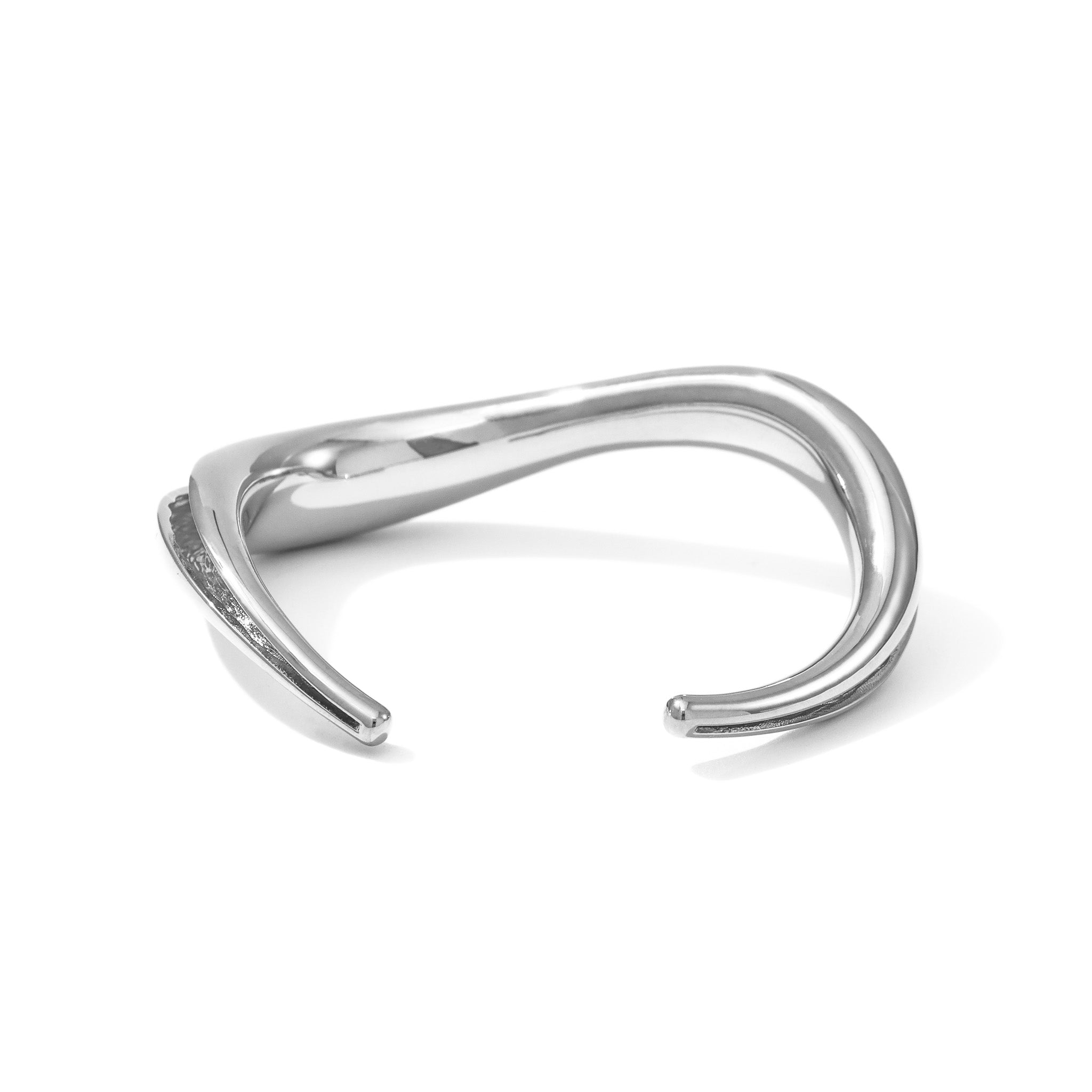 An open cuff bracelet with a smooth wave exterior and a textured inner channel.