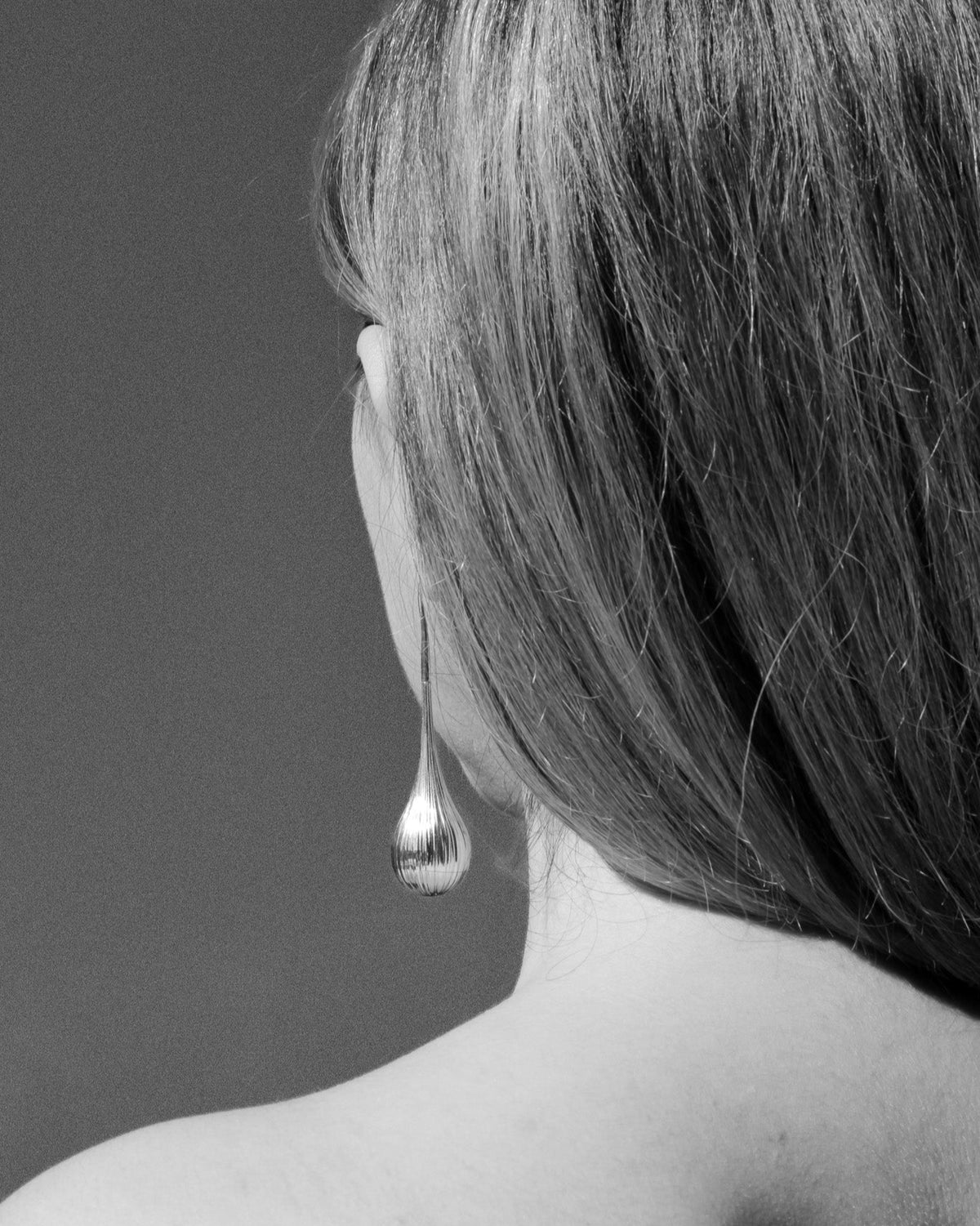 model wearing Cascade tear drop earrings inspired by waterfall texture in rhodium finish