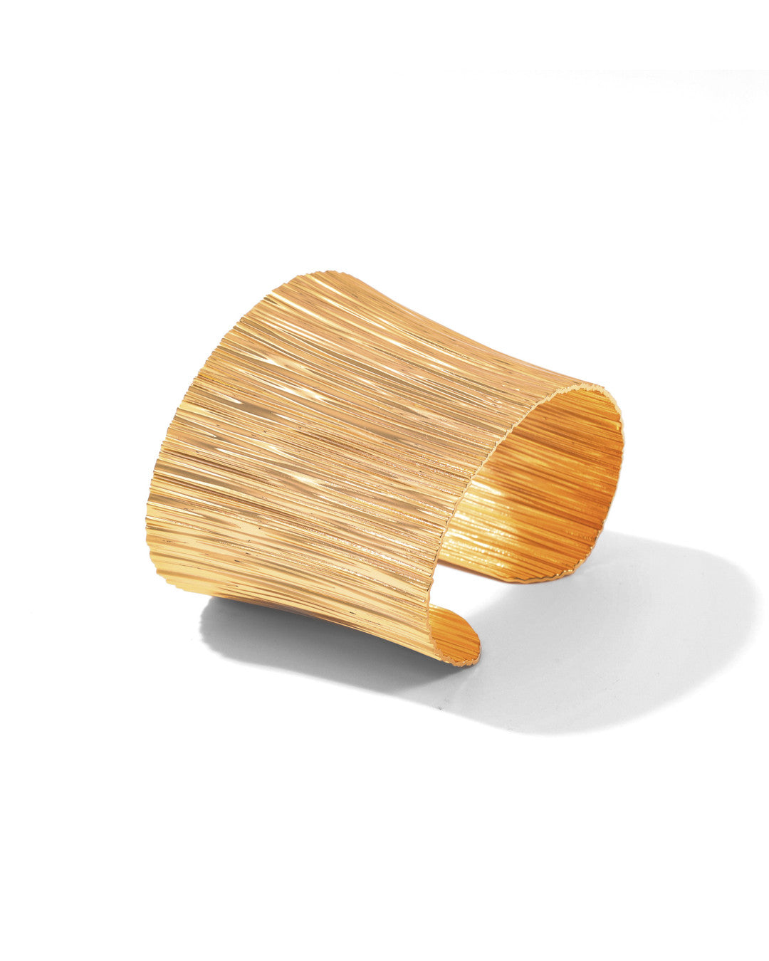 Gold Cascade cuff bracelet with a flared plunging silhouette and waterfall texture, on white