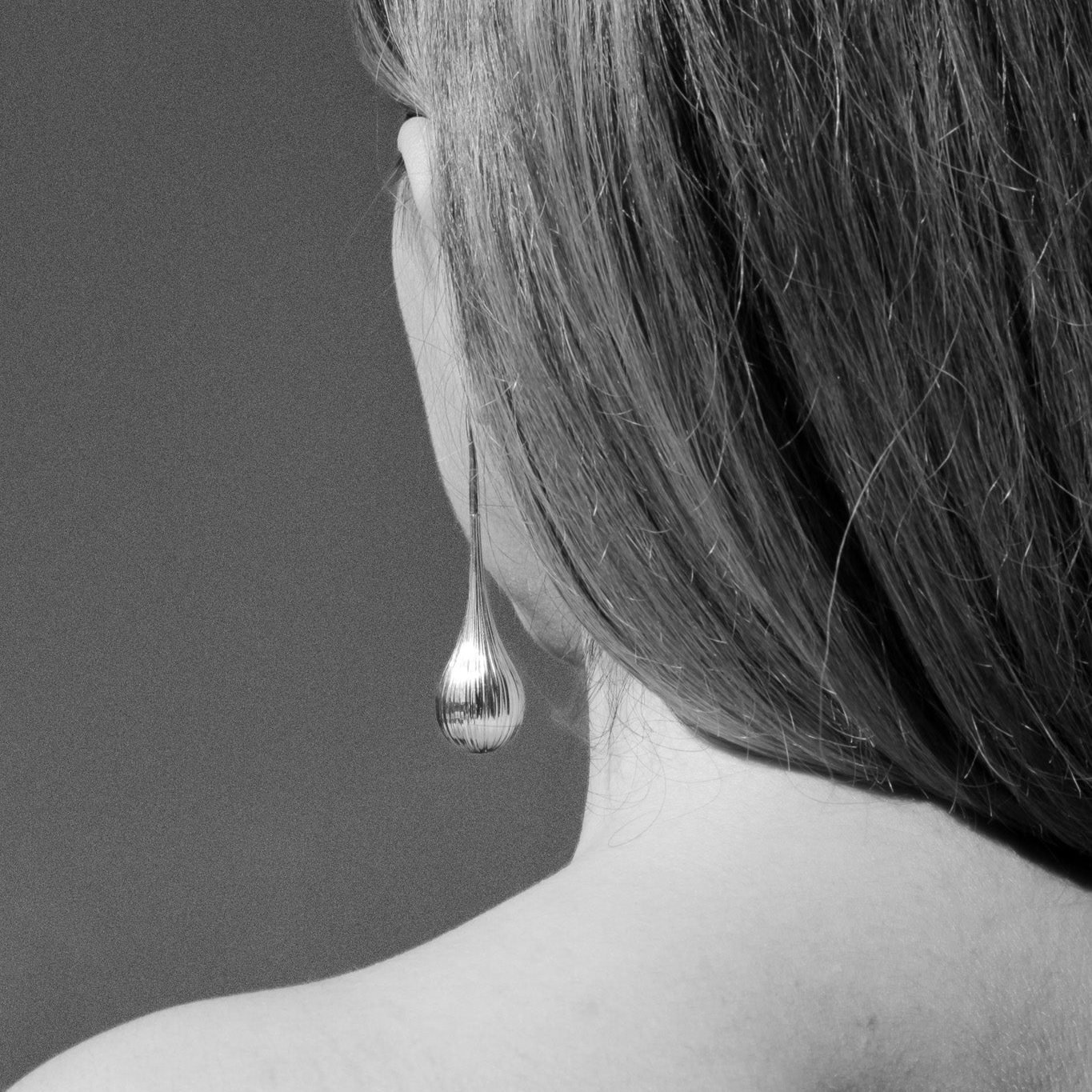 Side angle of the gold Cascade drop earrings showing the layered ridges