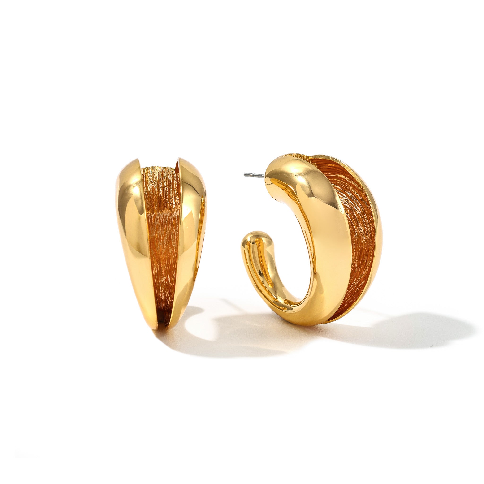 Gold Currents hoop earrings with a polished outer curve and textured inner surface, on white