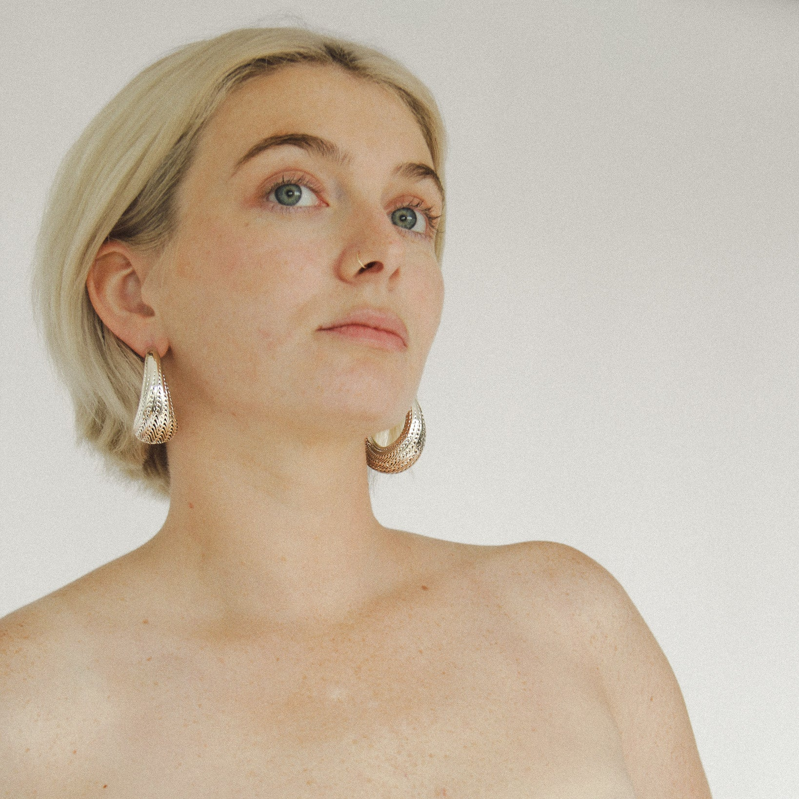 Side angle of the large gold Flow hoops showing the sculptural ridges