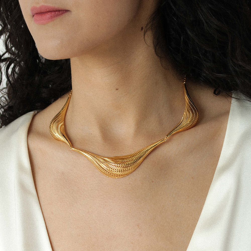 Model wearing the gold Flow Large statement necklace